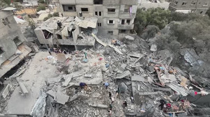 Palestinians inspect aftermath of house hit by Israeli strike in central Gaza