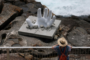 A woman looks at a sculpture titled ‘Surface Breach’ by artist Andre Braun on the opening day of the 'Sculpture by the Sea' outdoor exhibition in Bondi