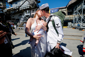 The US Navy Nimitz-class aircraft carrier USS Abraham Lincoln returns home following an extended deployment in the Middle East at Naval Base Coronado in San Diego