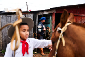 Farm worker rides on horseback with his grandson to cast his ballot in Brazil’s general election in southern Brazil