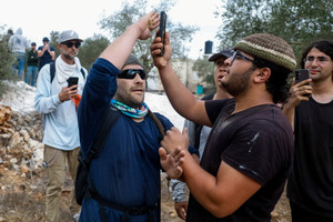 Israeli and foreign activists try to stop Israeli settlers from reaching Palestinians picking olives during the harvest season, in Palestinian-owned olive groves in the village of Turmus Ayya