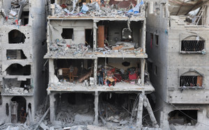Palestinians inspect the site of a house targeted by Israeli airstrikes, in Gaza City