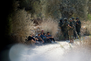 Israeli soldiers detain Palestinians at Palestinian-owned olive groves during the harvest season in the village of Beita near Nablus