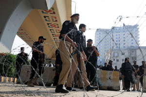 Police guard a road leading to Red Zone, in Peshawar