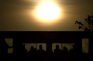 Commuters travel on a London Underground train at sunrise