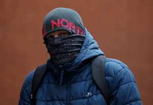 Sean Peers, one of the accused, covers his face as he arrives at Minshull Street Crown Court, as a group of men stand trial charged with serious sexual ‌offences against the same woman, in Manchester