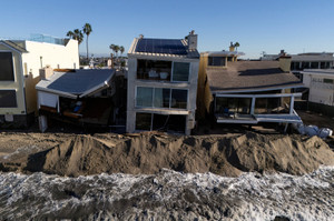 Sand berms built along the shoreline hold back waves during high in Long Beach