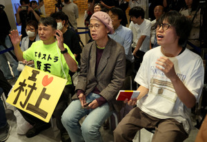 Fans of Japanese writer Haruki Murakami react as they watch the announcement of the 2026 Nobel Prize in Literature, awarded to Canadian poet Anne Carson, at a live-viewing event at a bookstore in Tokyo